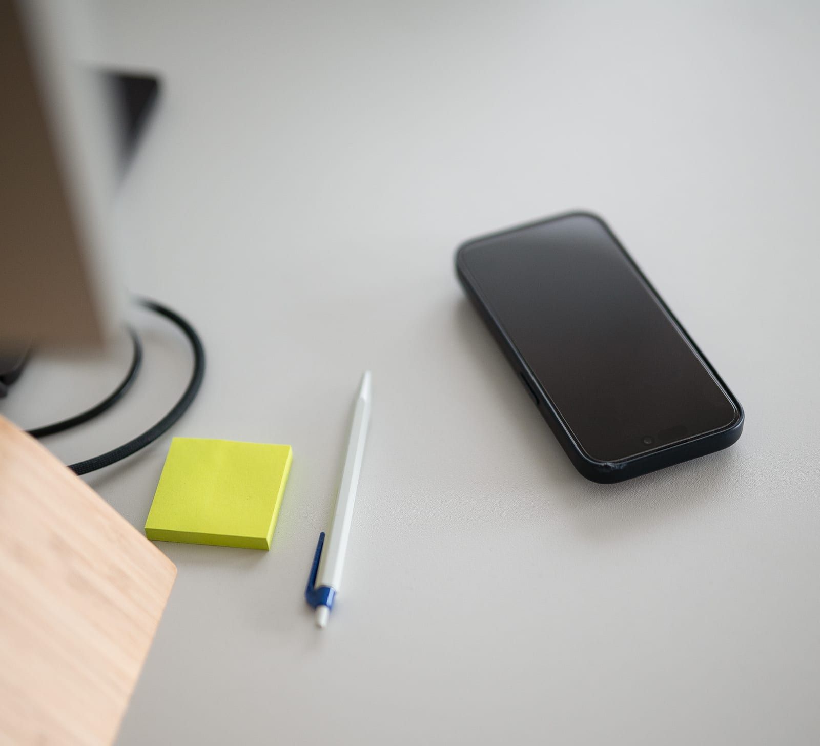 Telefon, Stift und Notizzettel auf einem Schreibtisch